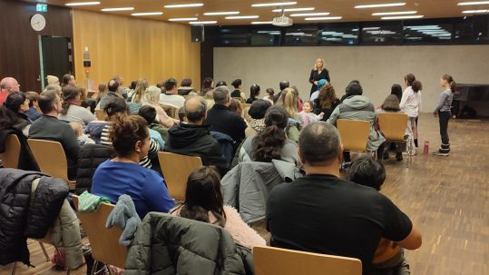 Die Eltern schauen sich die Tanz-Vorführungen ihrer Kinder an.